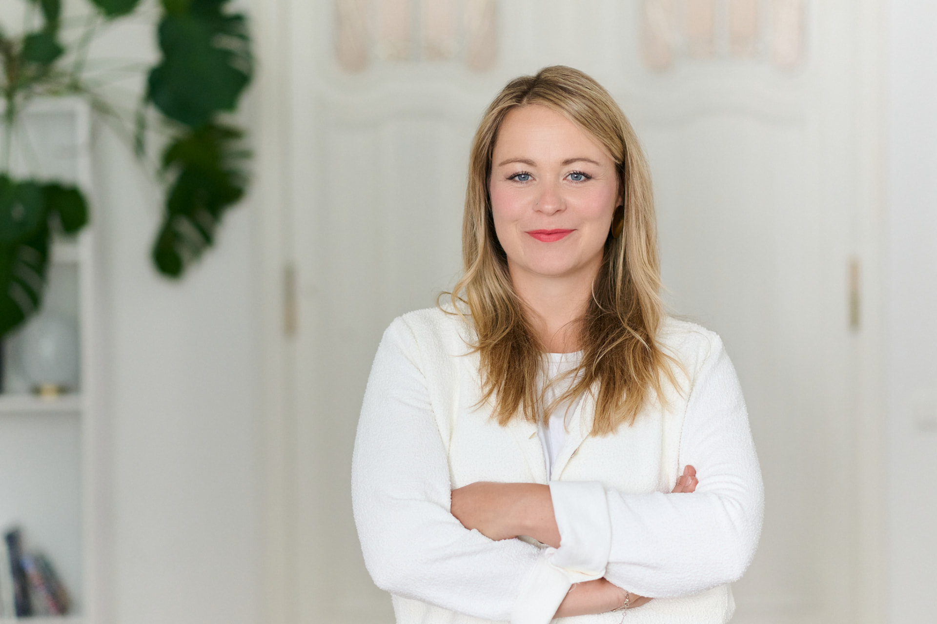 Nadine Herzog in weißer Jacke mit verschränkten Armen